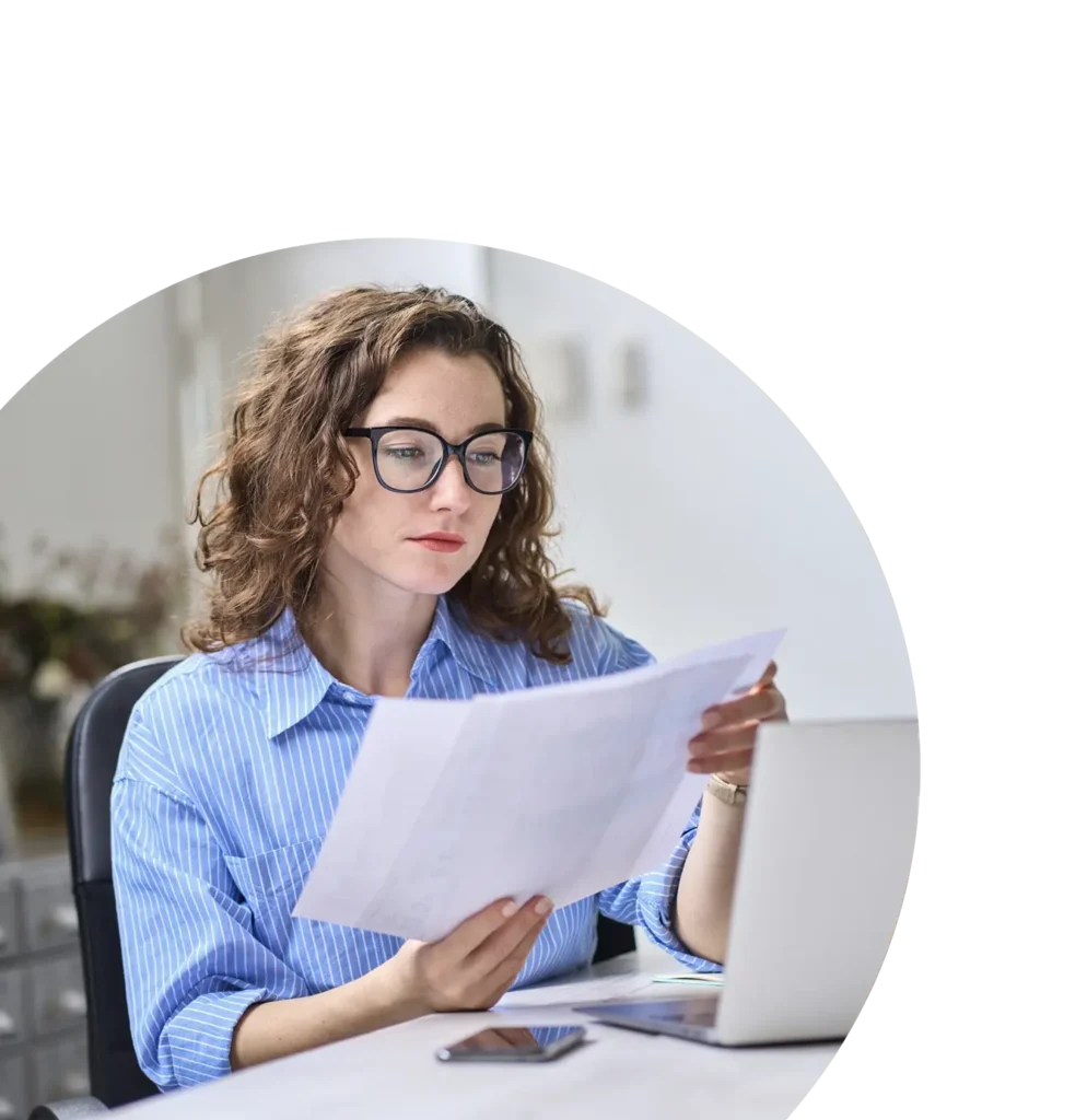 healthcare administrator at desk reviewing printouts of budget